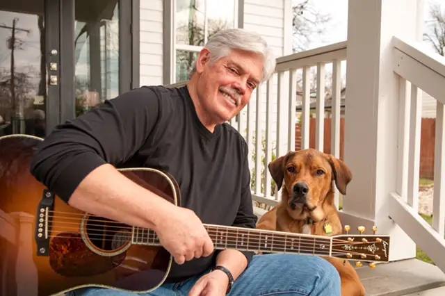 Enjoying some quality time with his loyal companion, guitar in hand and a smile that says it all. | Source: texashighways.com