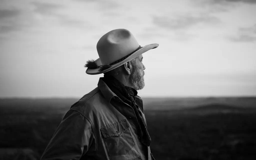 Standing tall against the horizon, a cowboy with a legacy as timeless as the land he surveys. | Source: texasmonthly.com