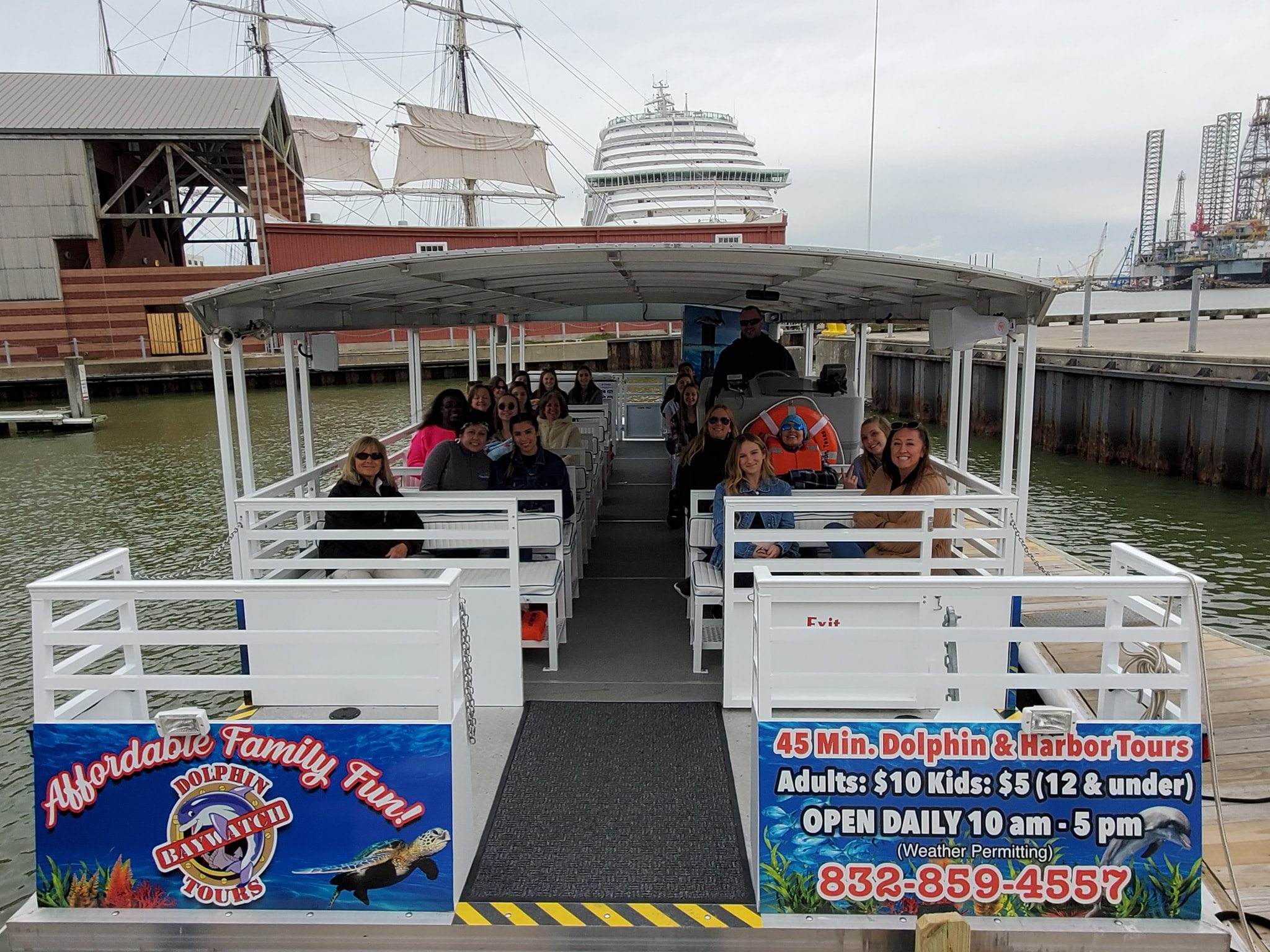 A group of people seated on a covered boat preparing for a dolphin and harbor tour near Galveston’s historic port.
