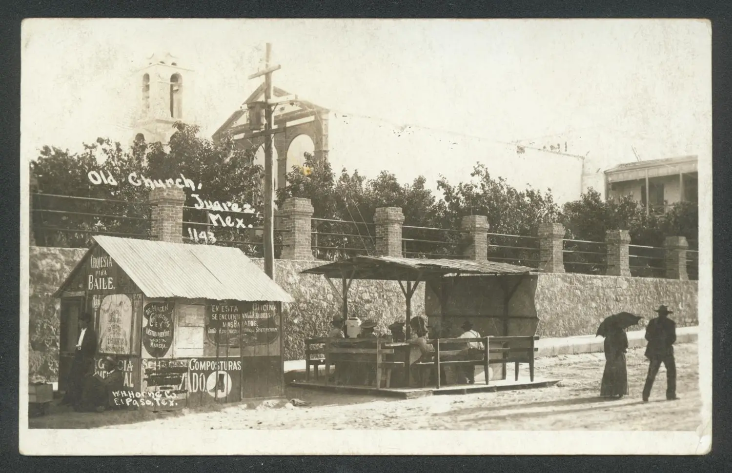 Vintage photograph of the Old Church in Juárez, Mexico, with people walking and a street vendor stand in the foreground.