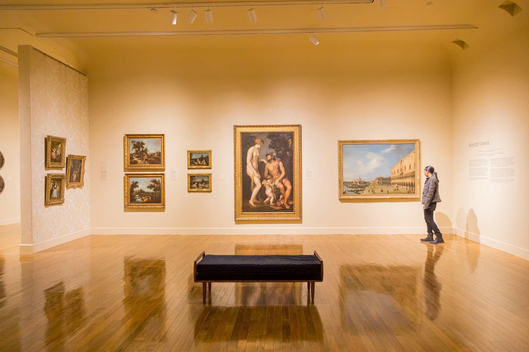 Interior view of the El Paso Museum of Art featuring classical paintings and a visitor observing an exhibition.