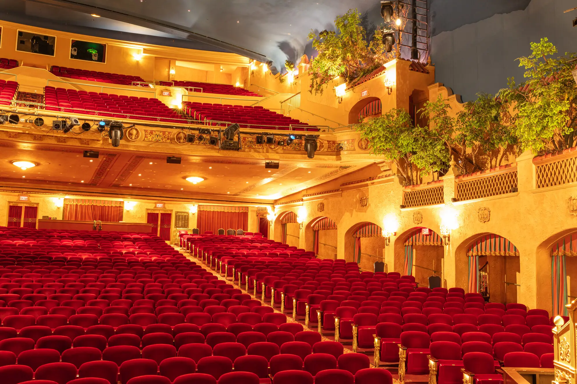 Interior of the historic Plaza Theatre in El Paso, featuring red velvet seats, ornate architecture, and stage lighting.