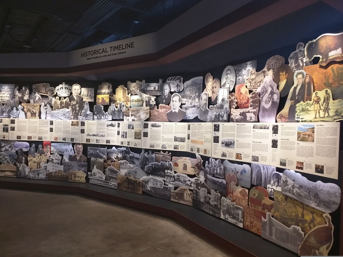 Colorful timeline display of historical photos, articles, and illustrations at Sugar Land Heritage Museum.