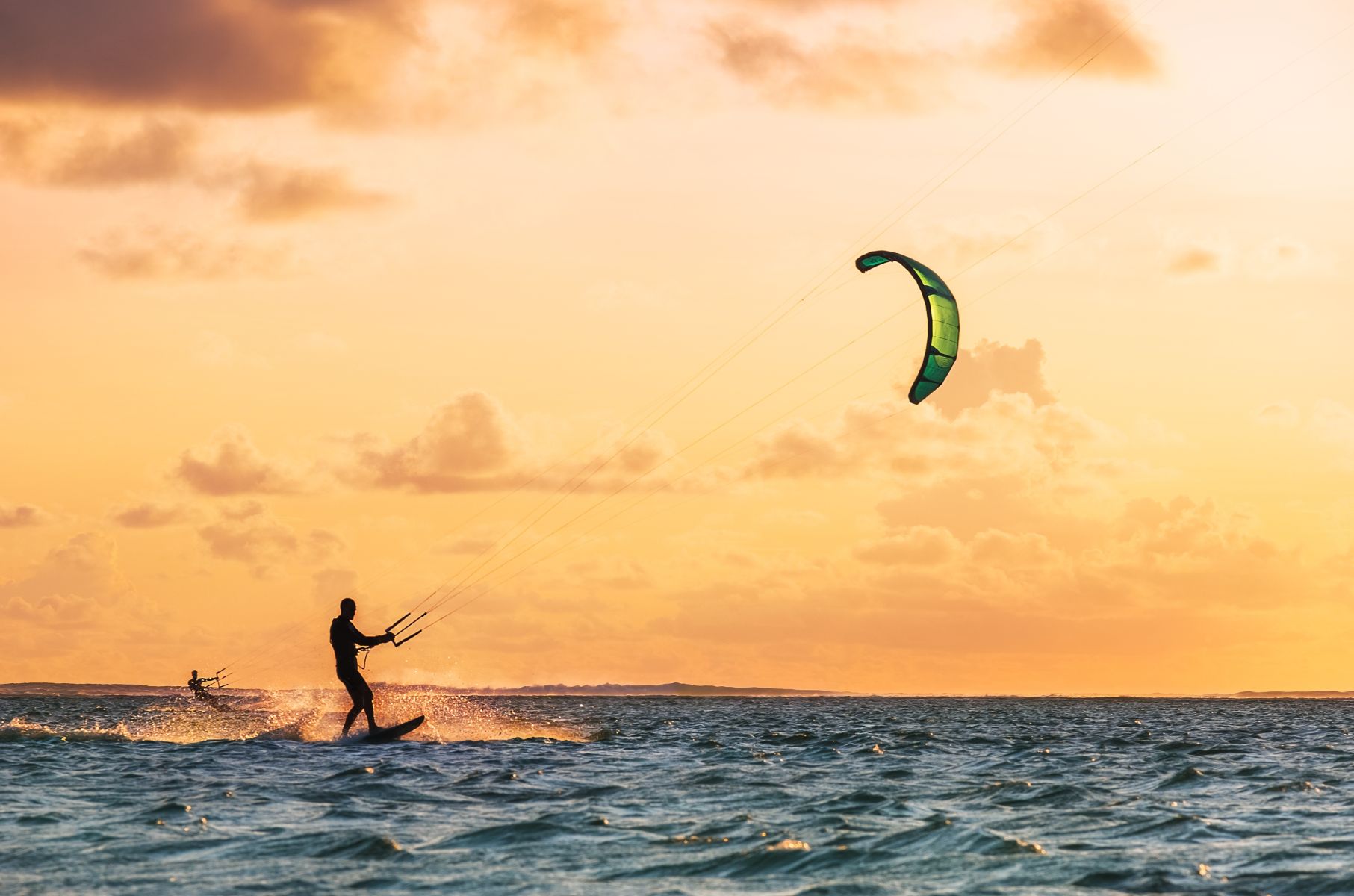 Person kite surfing at sunset on the ocean off South Padre Island.