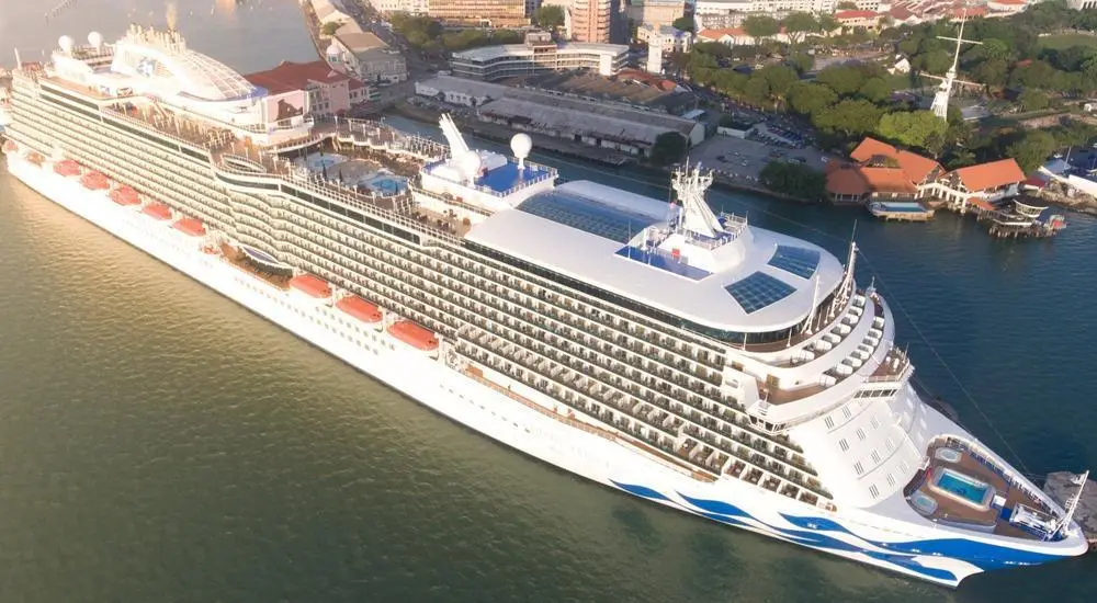 Princess Cruises ship sailing at sunset with pools and stateroom balconies visible.