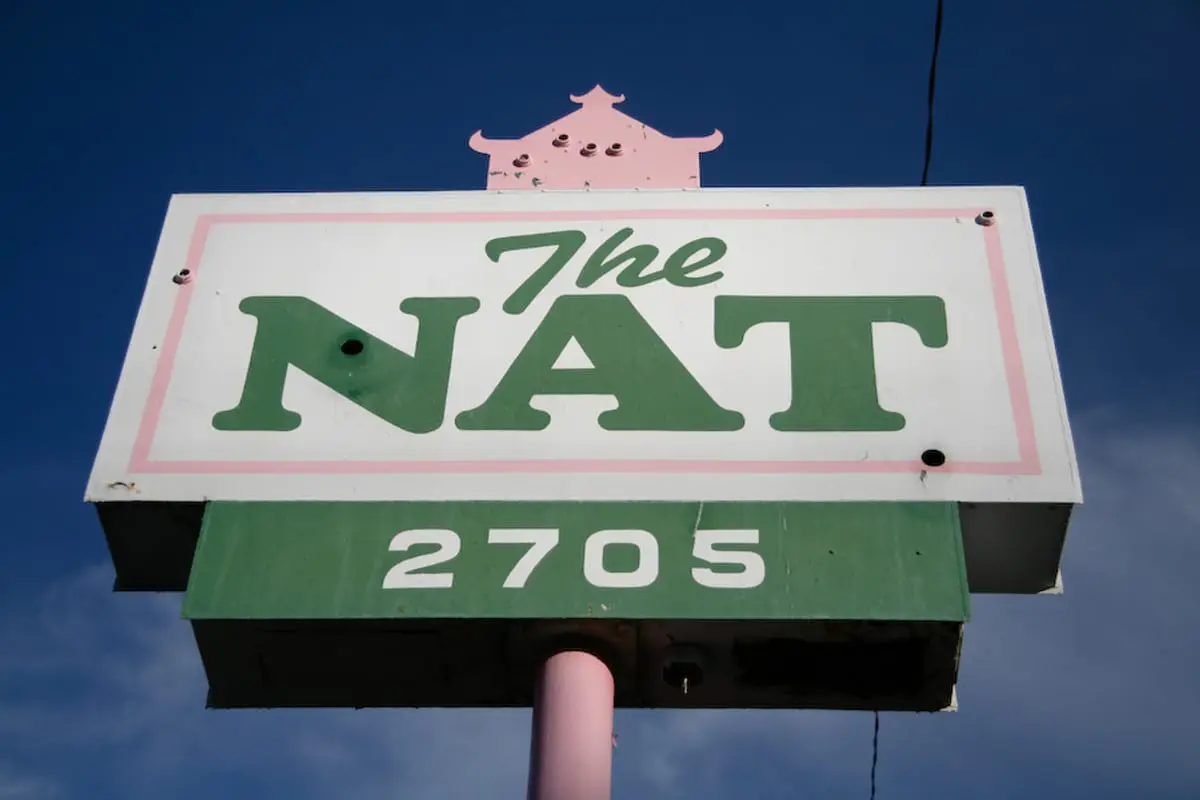 Vintage sign for The Nat Ballroom in Amarillo’s Historic District against a clear blue sky.