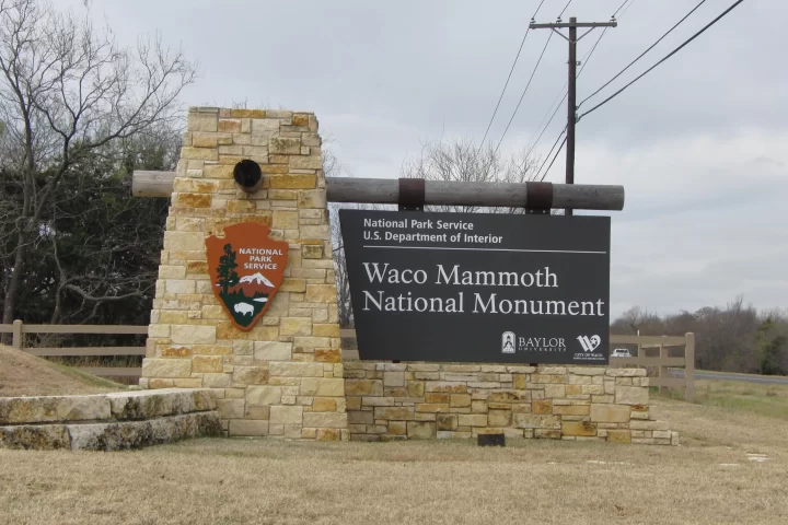 Stone sign marking the entrance to Waco Mammoth National Monument, managed by the National Park Service.