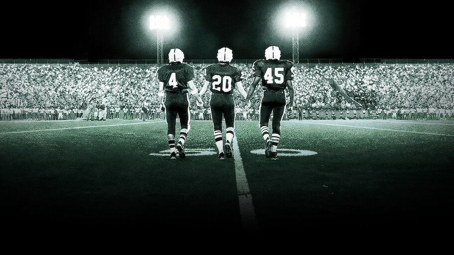 Three football players walking onto a lit stadium field at night, symbolizing Texas’s cinematic legacy in sports dramas.