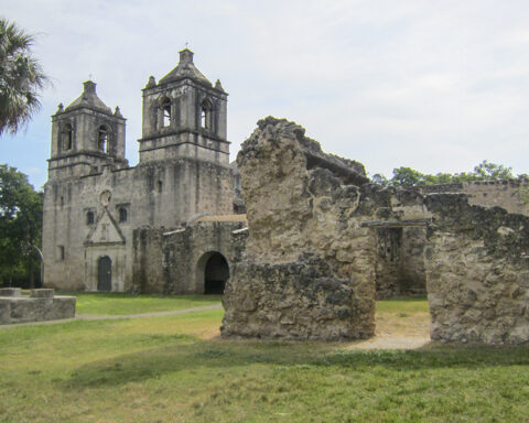 Mission Concepción in San Antonio, one of the oldest churches in Texas, surrounded by historic stone ruins and greenery during the holiday season.