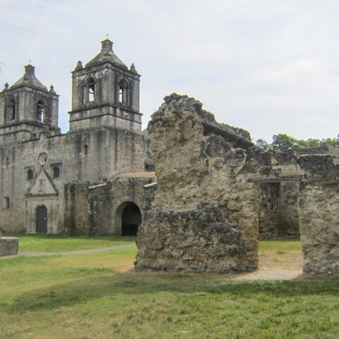 Mission Concepción in San Antonio, one of the oldest churches in Texas, surrounded by historic stone ruins and greenery during the holiday season.