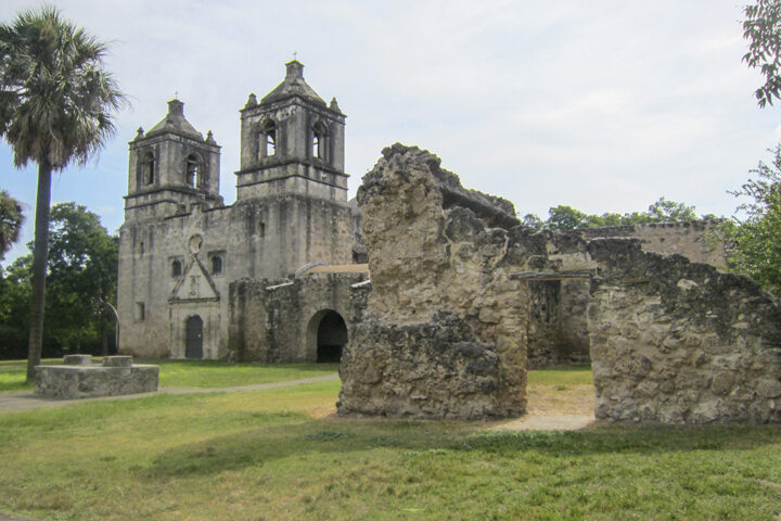 Mission Concepción in San Antonio, one of the oldest churches in Texas, surrounded by historic stone ruins and greenery during the holiday season.