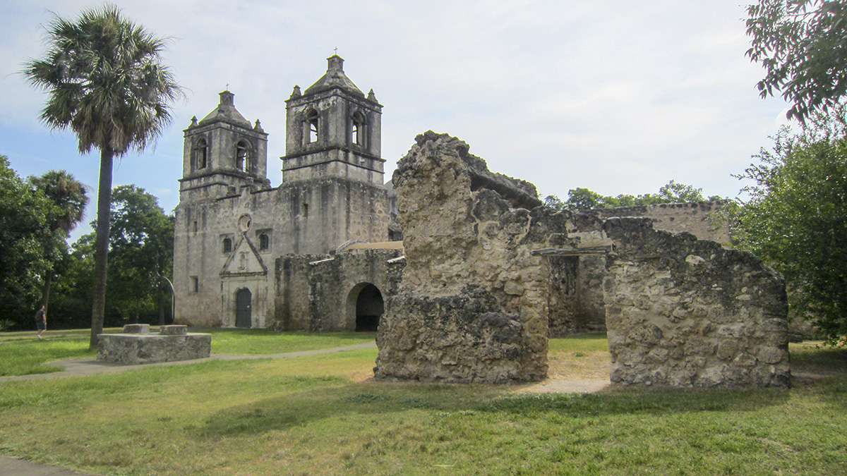 Mission Concepción in San Antonio, one of the oldest churches in Texas, surrounded by historic stone ruins and greenery during the holiday season.