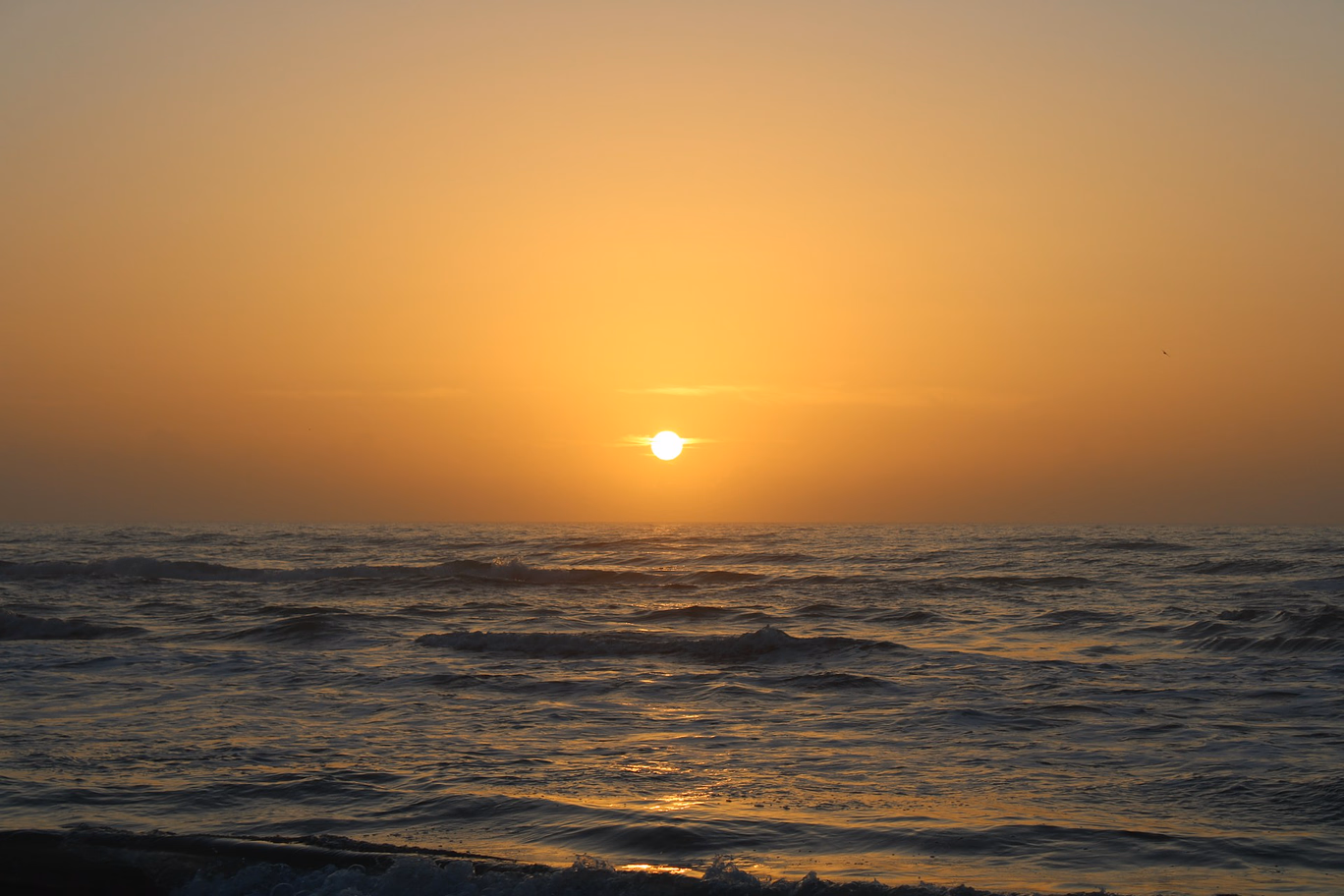 Golden sunrise above the ocean at South Padre Island, capturing the peaceful charm of a top Texas beach.