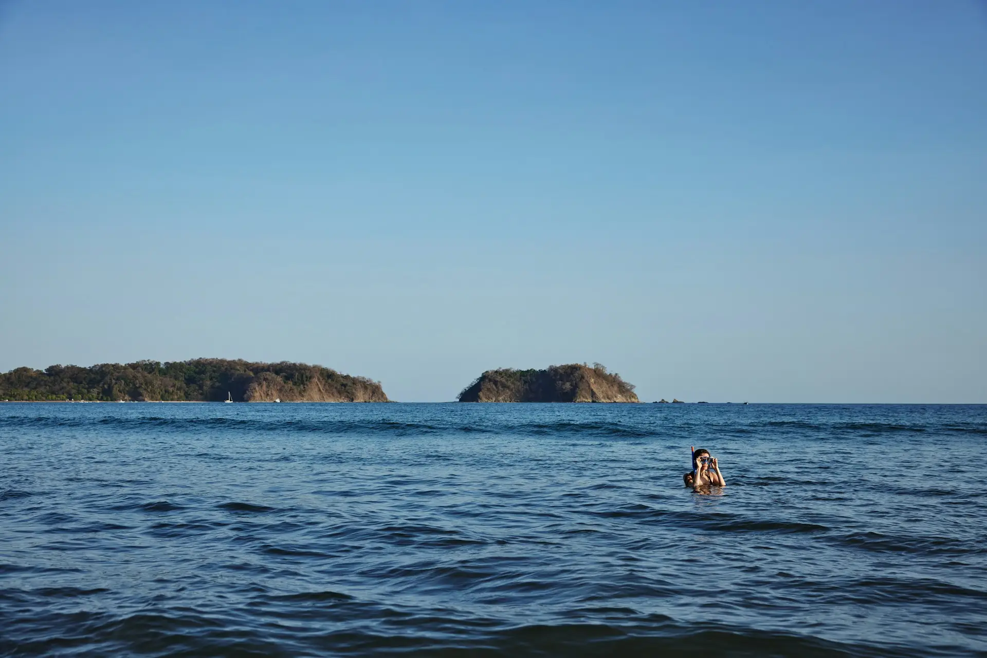 Person snorkeling in calm water with small offshore islets in Subtropical Texas.