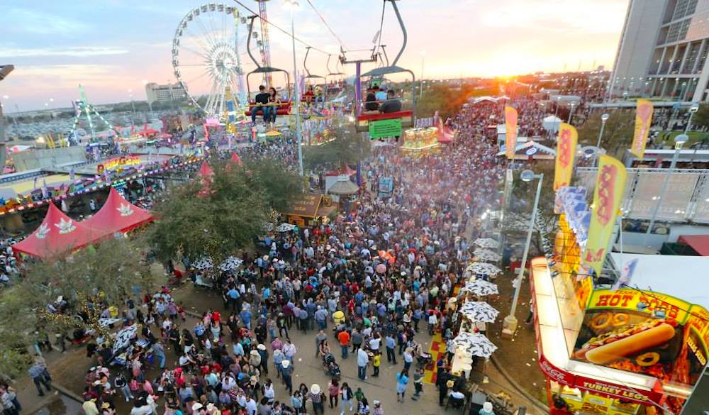 Crowds at the 2026 Houston Rodeo fairgrounds with rides, food booths, and citywide festivities