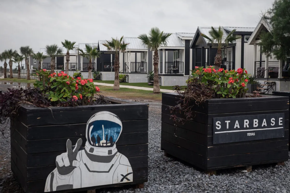 Row of modern tiny homes and astronaut-themed planters near SpaceX Starbase, showing what it’s like to visit Starbase.