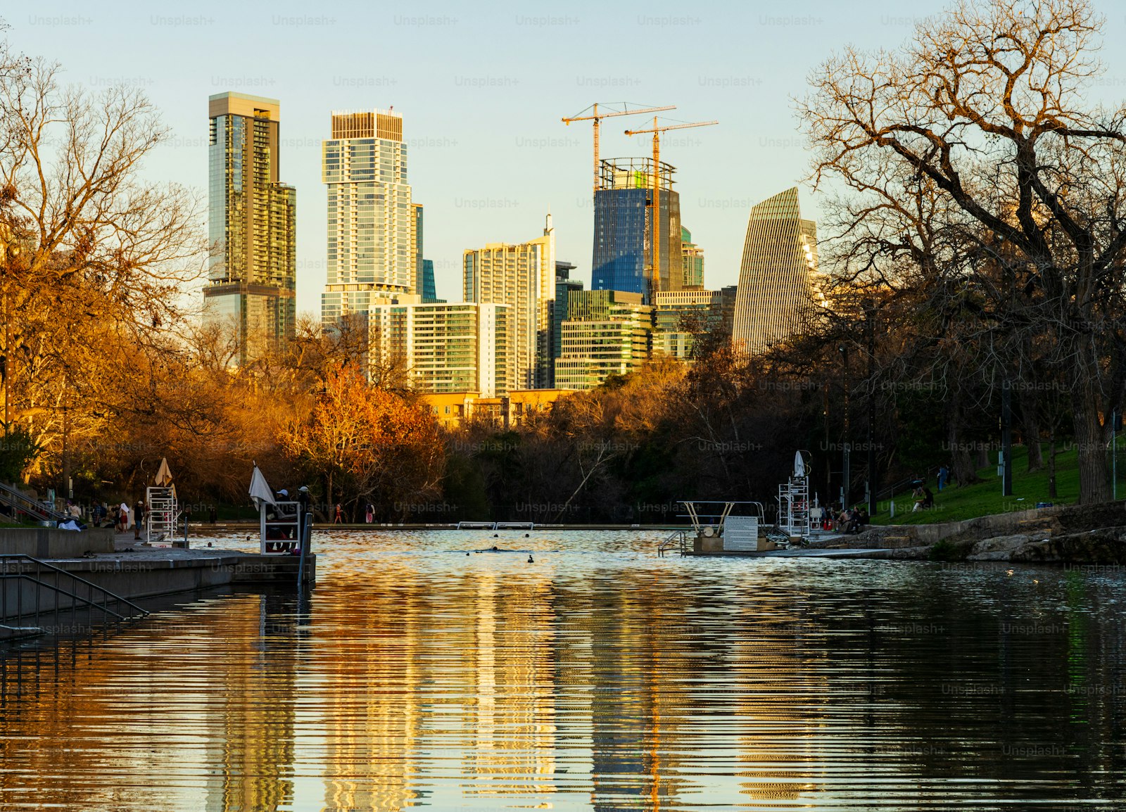 Fall color around Barton Springs Pool, with the downtown Austin skyline beyond.