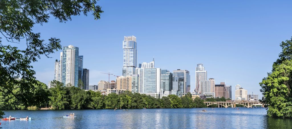 Barton Springs Pool in Zilker Park, with downtown Austin rising behind the trees.