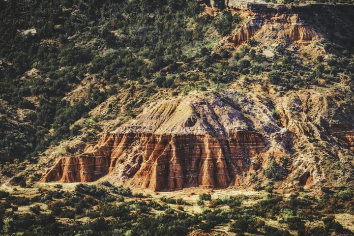 Bands of red, white, and lavender rock, often called the Spanish Skirts, line the cliffs of Palo Duro Canyon
