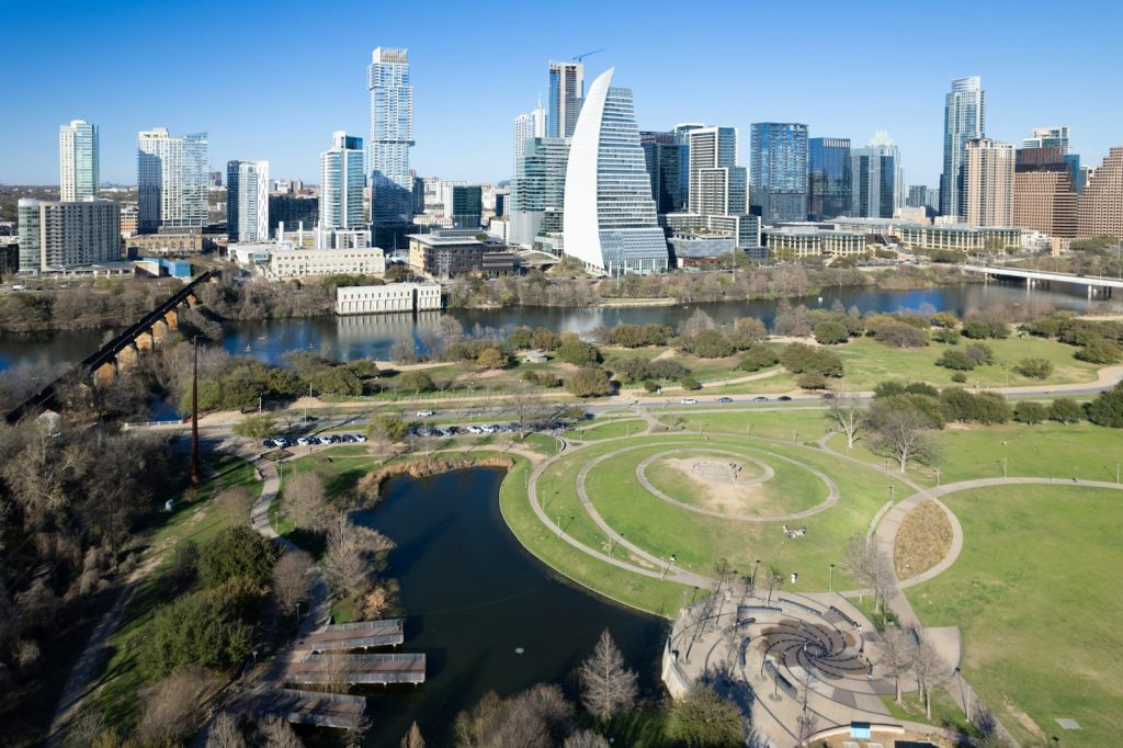 Zilker Park and Barton Springs from above, with downtown Austin in the distance.